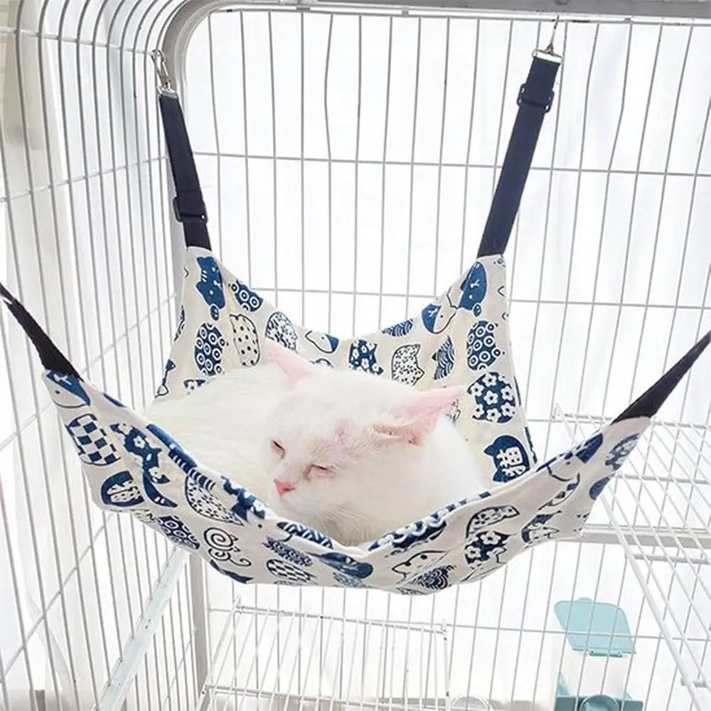 Hamac pour chat blanc cassé et bleu à motifs, suspendu dans une cage