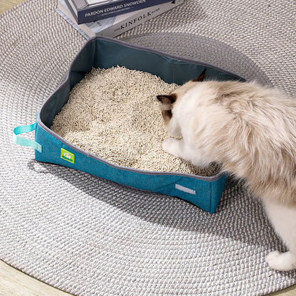Bac à litière pliable bleu pour chat avec litière, chat blanc et beige.