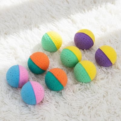 Balles pour chat colorées texturées sur tapis blanc