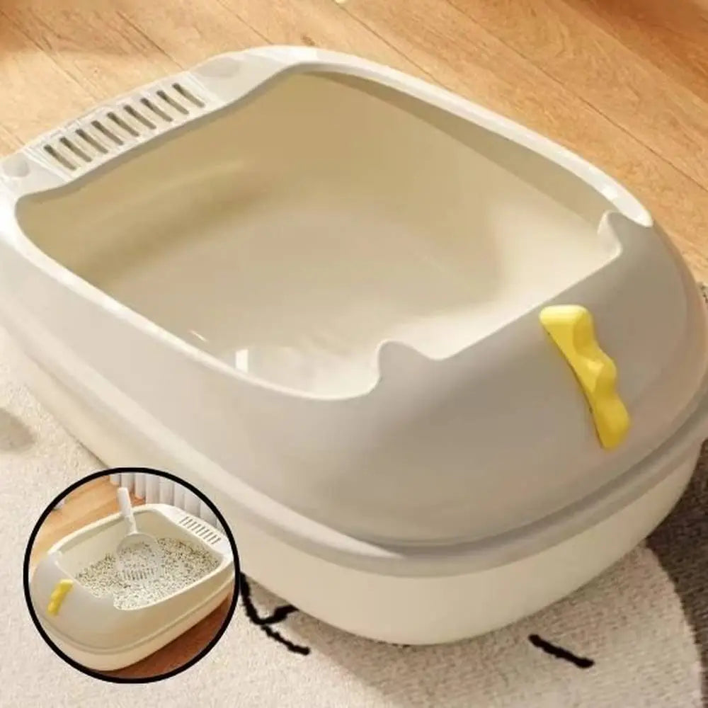 Bac à litière pour chat beige/blanc vu de dessus, pelle jaune sur le côté du bac.