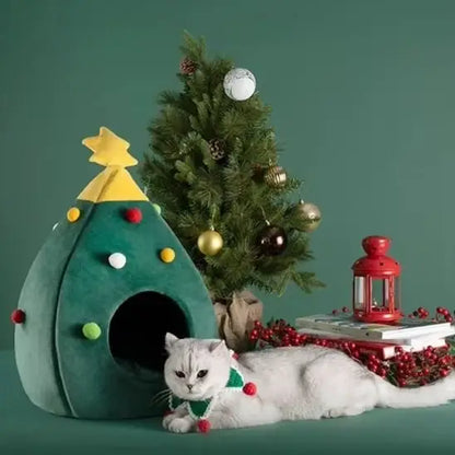 Maison pour chat sapin verte en tissu, chat blanc allongé devant l’ouverture.