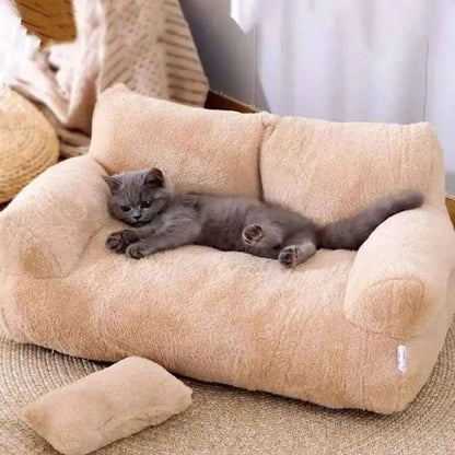 Panier pour chat en peluche beige, rebords rembourrés en U, chat gris allongé.