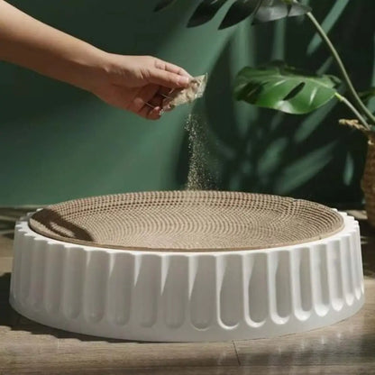 Griffoir rond pour chat avec base blanche cannelée et plateau de grattage beige.