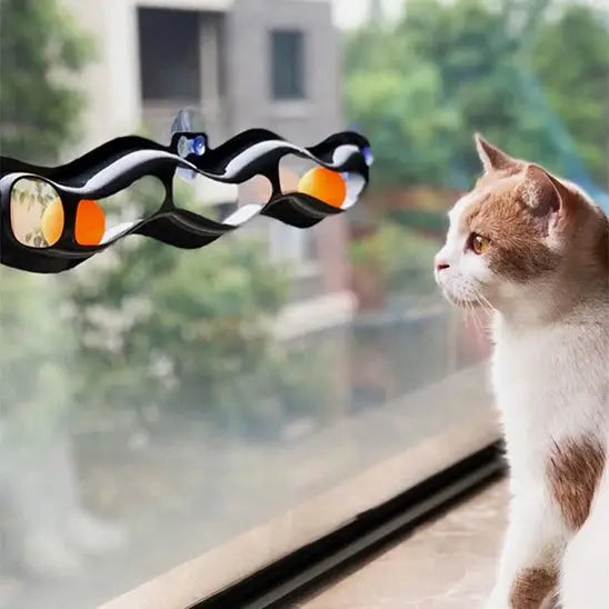 Jouet interactif pour chat à ventouses, barre noire ondulée avec détails orange et bleus, chat roux
