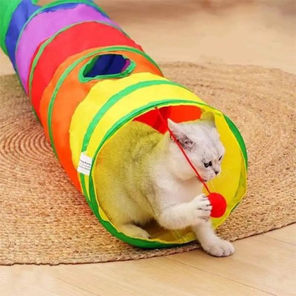 Tunnel pour chat pliable multicolore sur tapis, entrée jaune et balle rouge.
