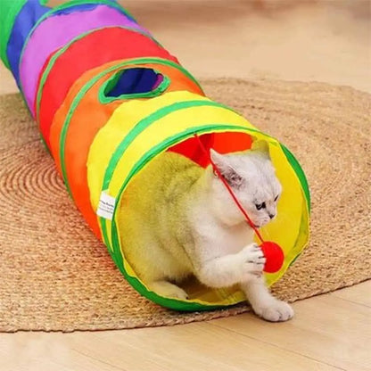 Tunnel pour chat pliable multicolore sur tapis, entrée jaune et balle rouge.