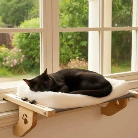 Hamac pour chat de fenêtre: coussin blanc, cadre bois, chat noir couché dessus.