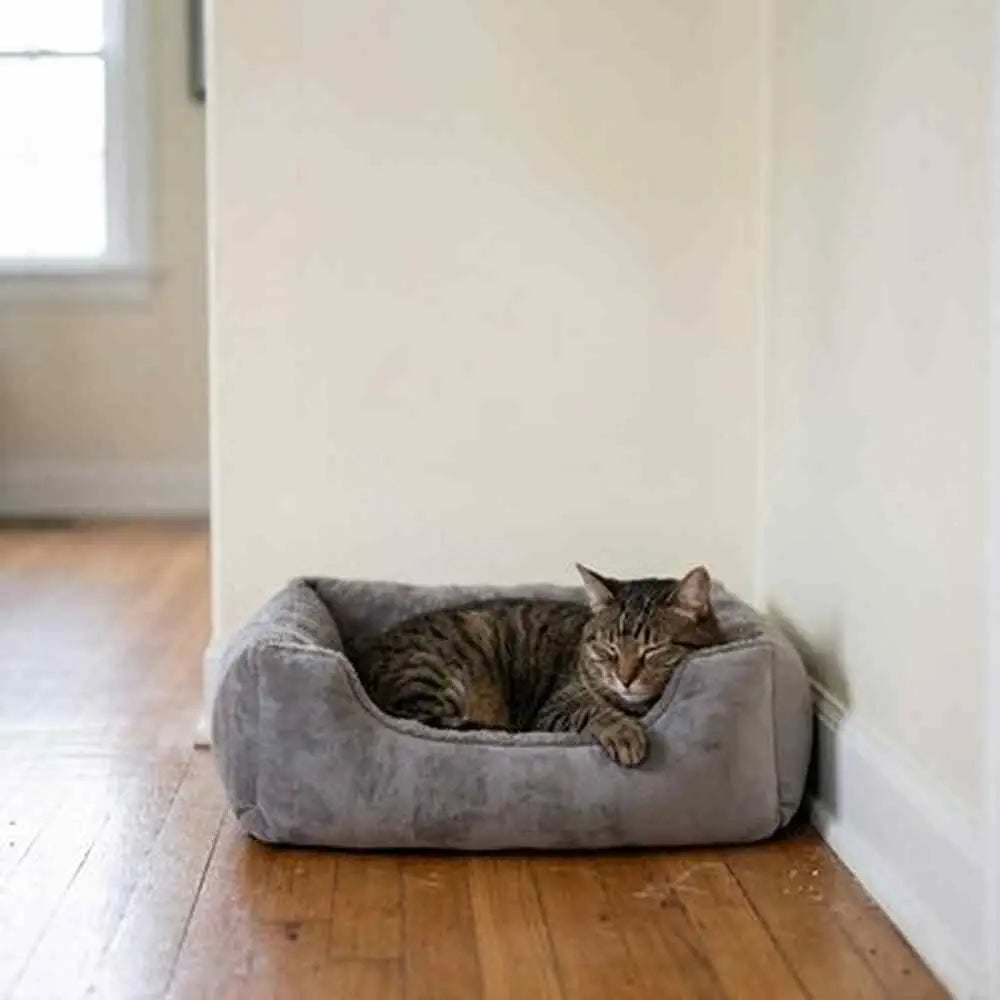 Panier pour chat rectangulaire en tissu gris, coussin central et rebords souples.