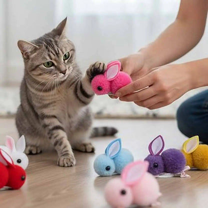 Jeu de peluches lapins pour chat : lapin rose en tissu tenu par une main