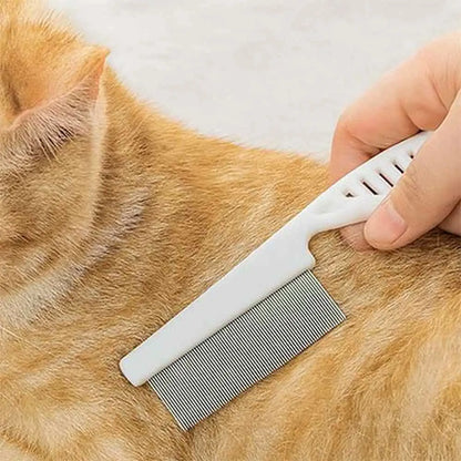 Peigne à chat anti-nœuds blanc avec dents métalliques, sur pelage roux