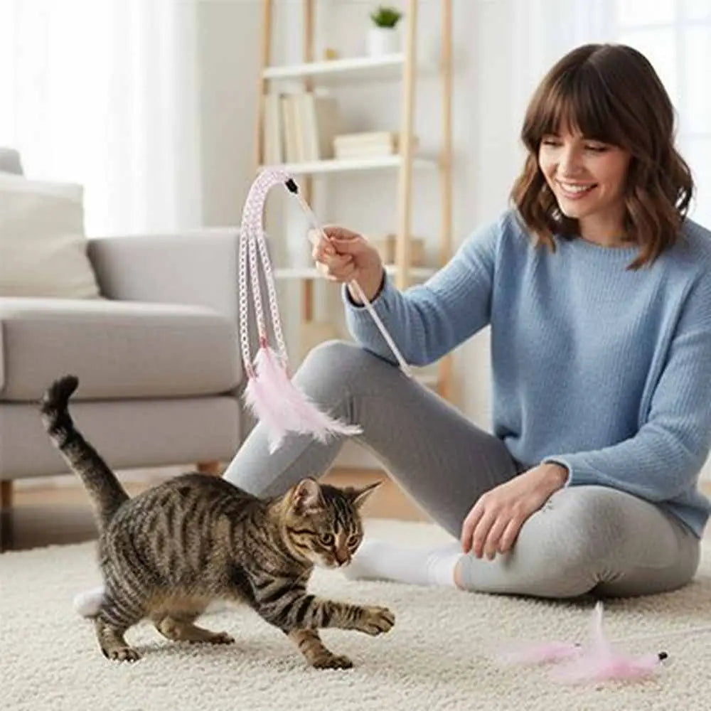 Baguette chenille pour chat avec plume rose, chat tigré qui joue près d’une personne