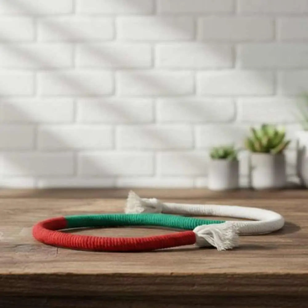Anneau de jeu pour chat en tissu rouge, vert et blanc, avec plume blanche.