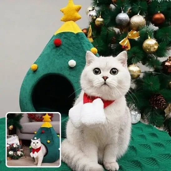 Maison pour chat sapin verte, chat blanc assis devant l’ouverture, nœud rouge.