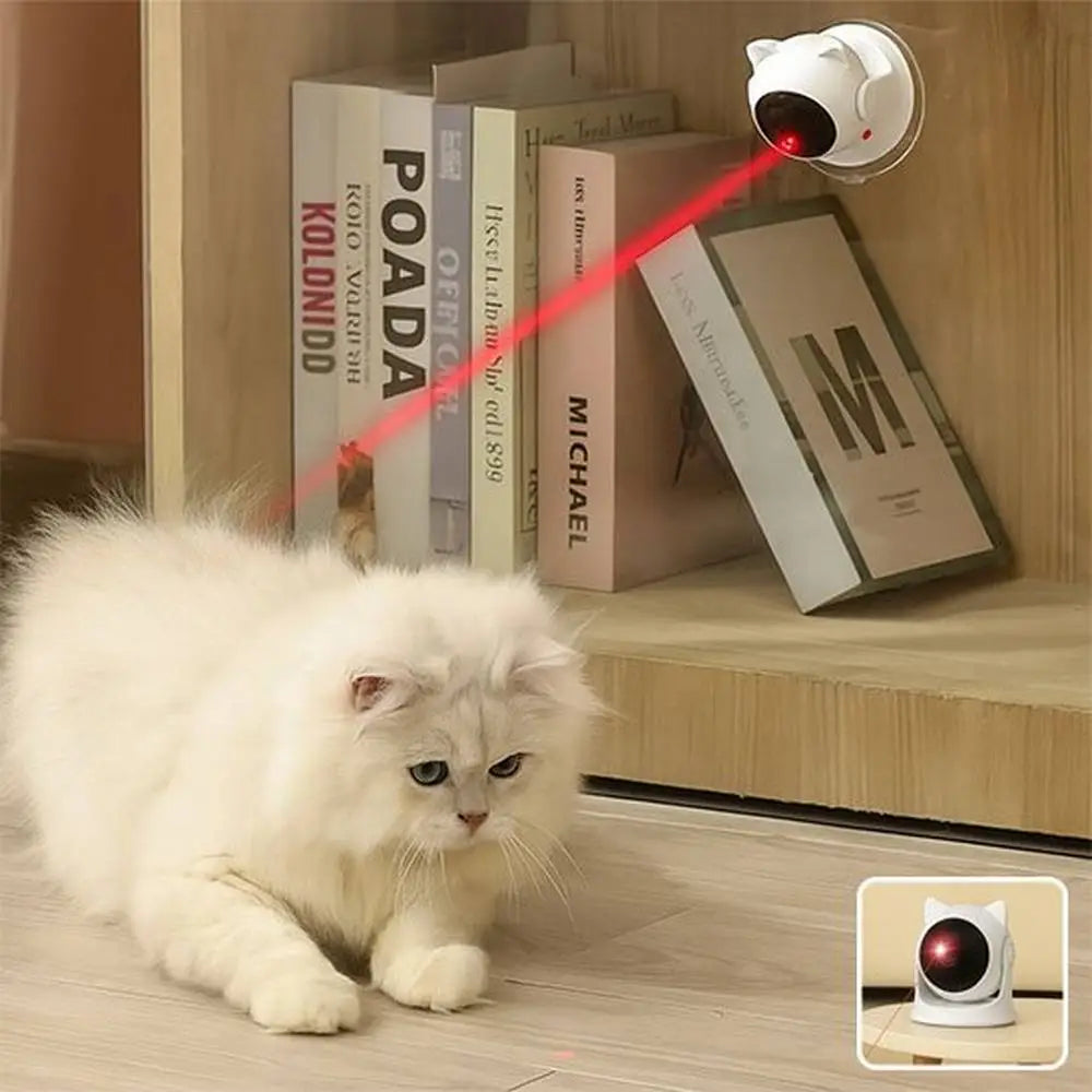 Jouet interactif blanc projettant un faisceau rouge vers un chat blanc couché.