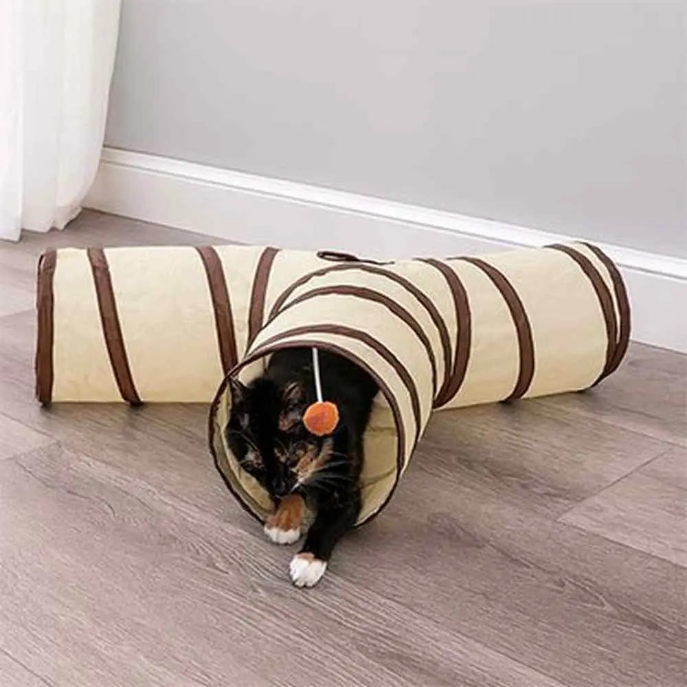 Tunnel pour chat en tissu crème rayé marron, chat noir sortant de l’ouverture.