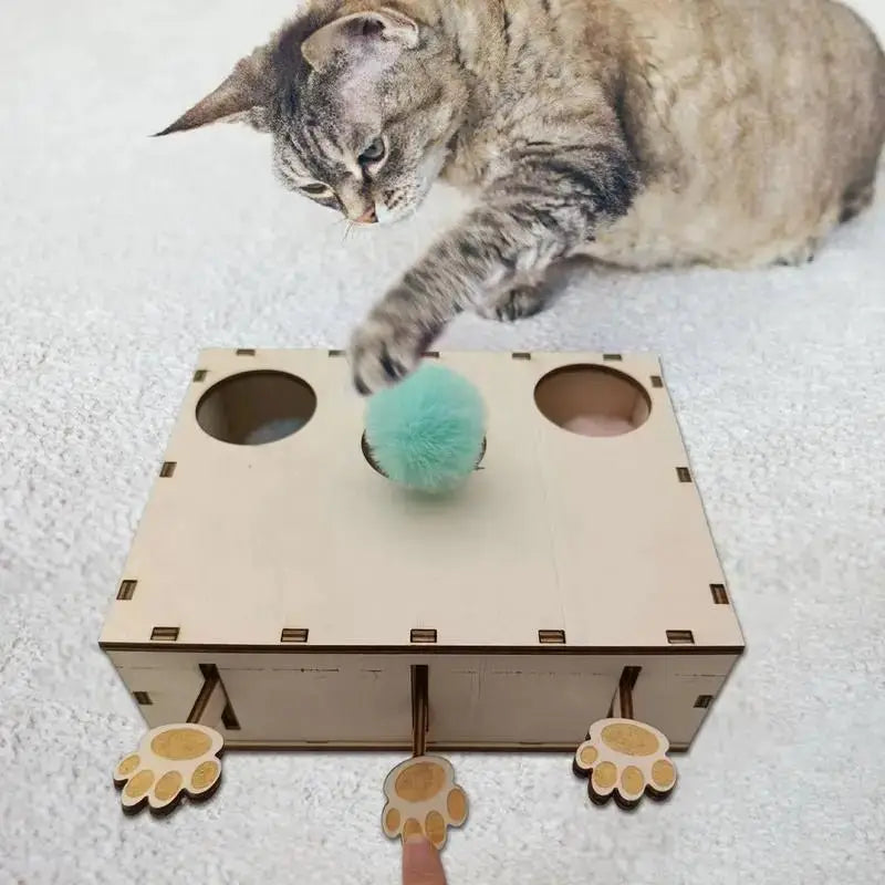 Jouet interactif CatWhack™ en bois clair, trous ronds et peluche turquoise au centre