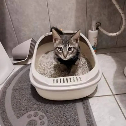 Bac à litière pour chat blanc/beige avec rebord ajouré et litière, vu rapproché.