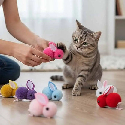 Jeu de peluches lapins pour chat : lapin rose en tissu, chat près de peluches