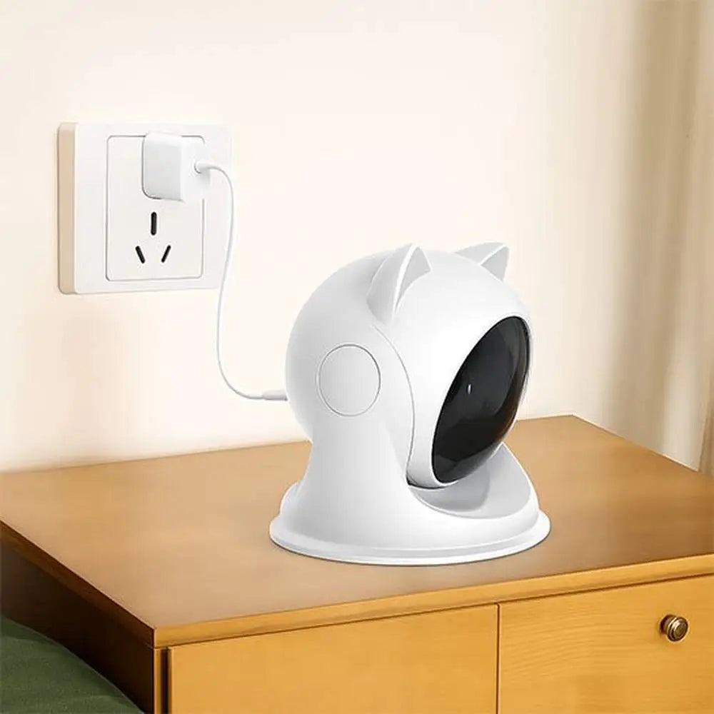 Jouet interactif pour chat blanc à tête ronde noire sur une table.