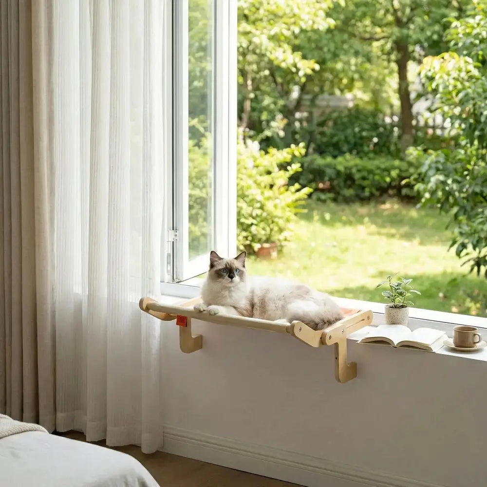 Lit suspendu pour chat près de la fenêtre, plateforme beige sur supports en bois