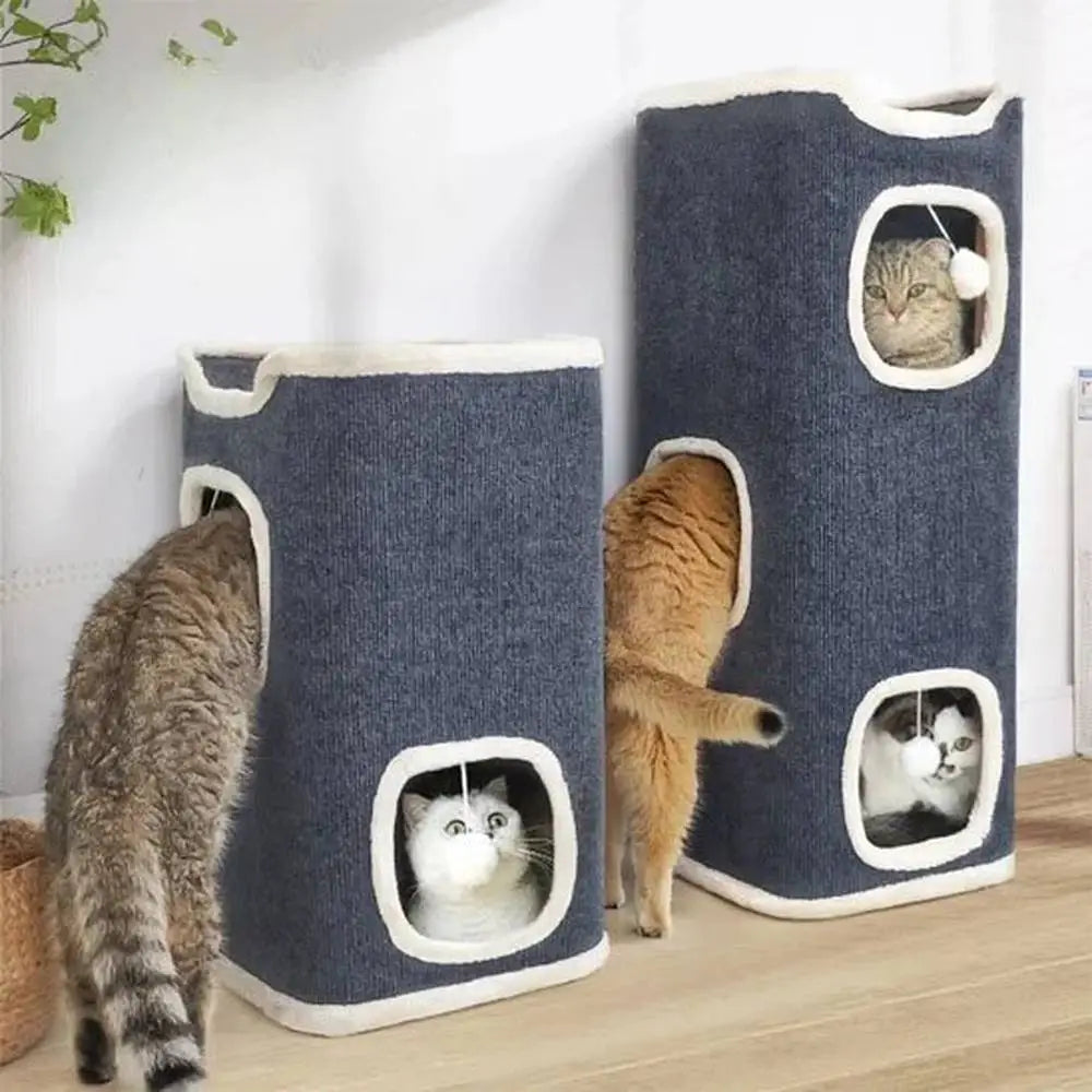 Arbres à chat gris foncé avec ouvertures bordées de blanc, deux cabanes et balles pendantes.