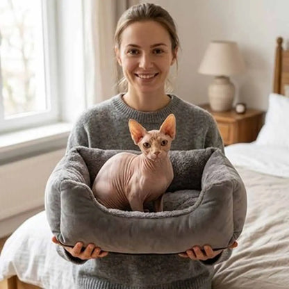 Panier pour chat en tissu gris, ouvert avec coussin, chat reposant à l’intérieur.