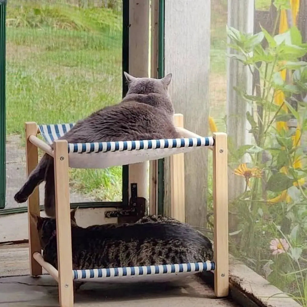 Hamac pour chat Cozy-Perch à rayures bleu et blanc, cadre en bois, chat gris sur l’étage