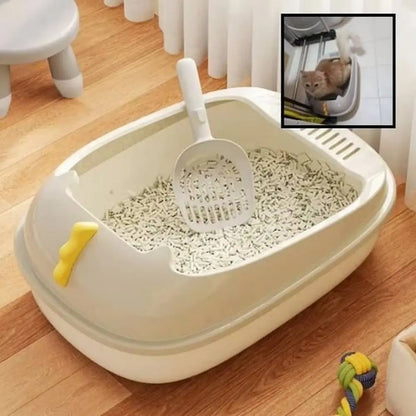 Bac à litière pour chat beige/blanc avec pelle à trous, intérieur rempli de litière sur sol.