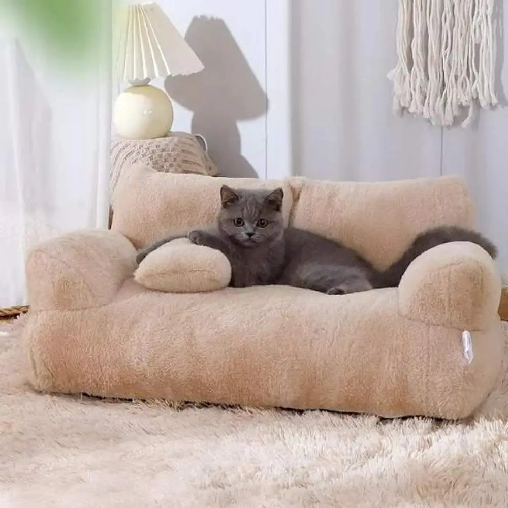 Panier pour chat en peluche beige, forme canapé avec coussins d’angle arrondis.