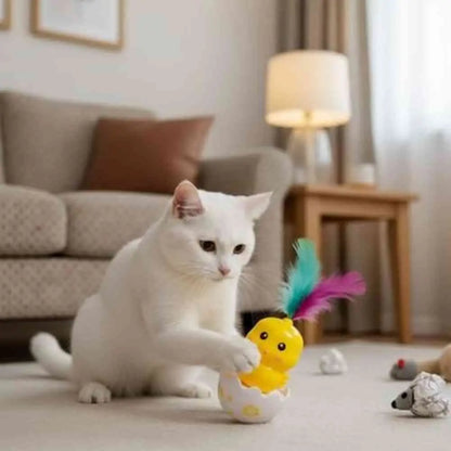 Jeu interactif pour chat : jouet poussin jaune à plumes arc-en-ciel sur base blanche.