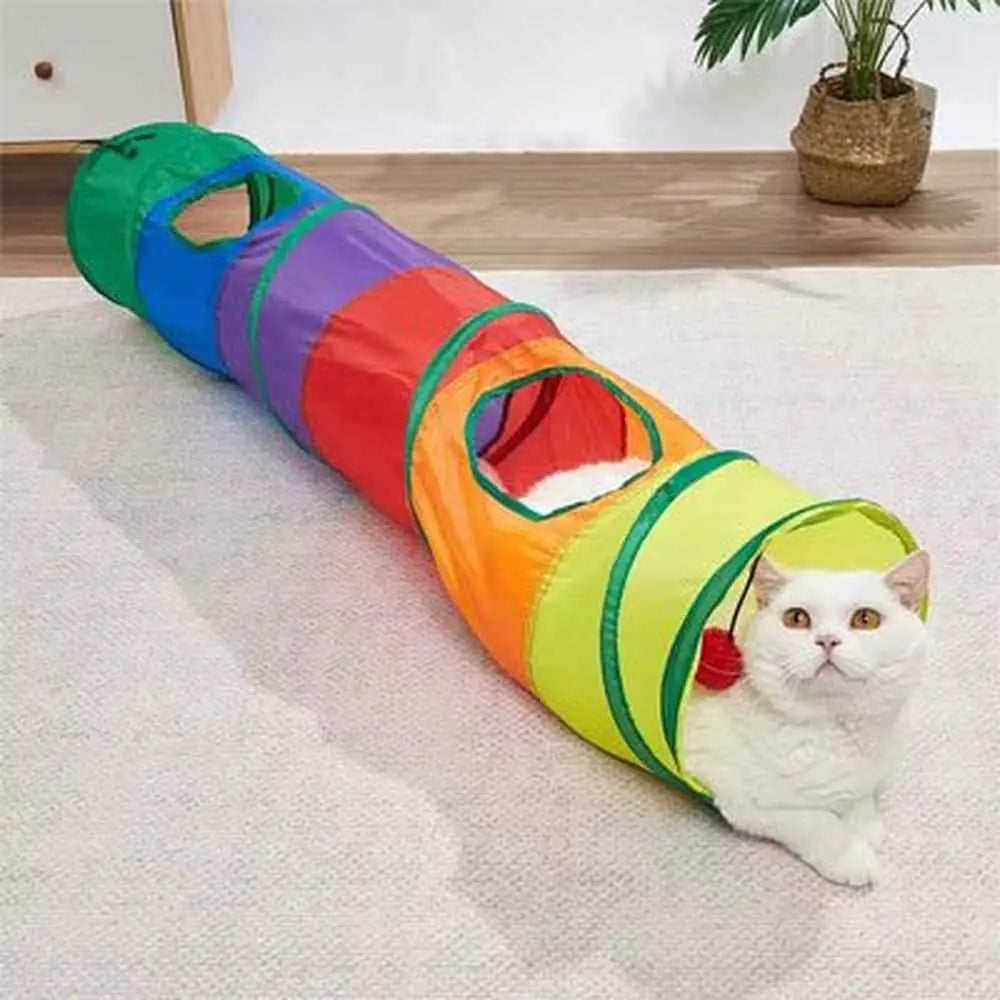 Tunnel pour chat pliable multicolore sur tapis clair, entrée jaune et balle rouge.
