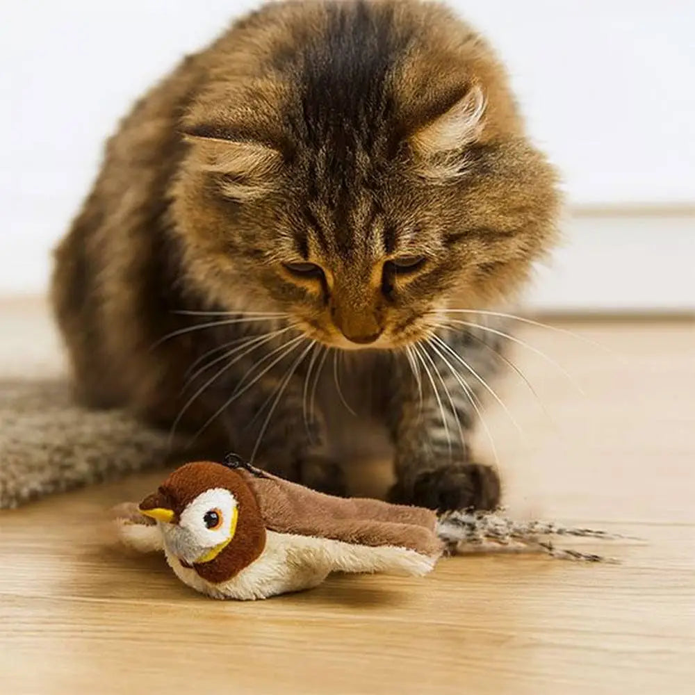 Jouet oiseau en peluche brun avec bec jaune et yeux ronds, au sol