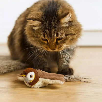Jouet oiseau en peluche brun avec bec jaune et yeux ronds, au sol
