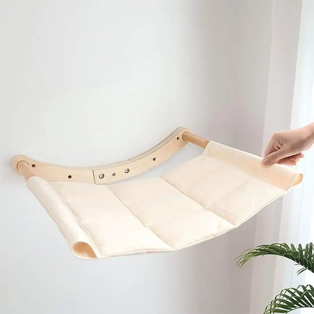 Hamac chat ultra-doux plié: tissu blanc, barres en bois clair, sangles